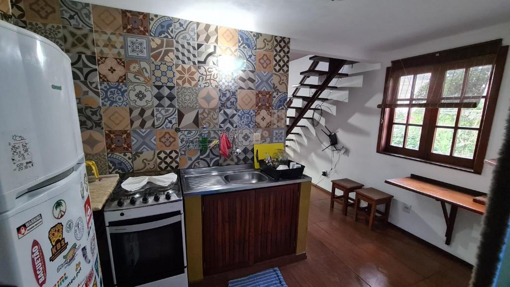 y cocina con fogones, fregadero y nevera. en Linda Surf House Apartamentos, en Itacaré