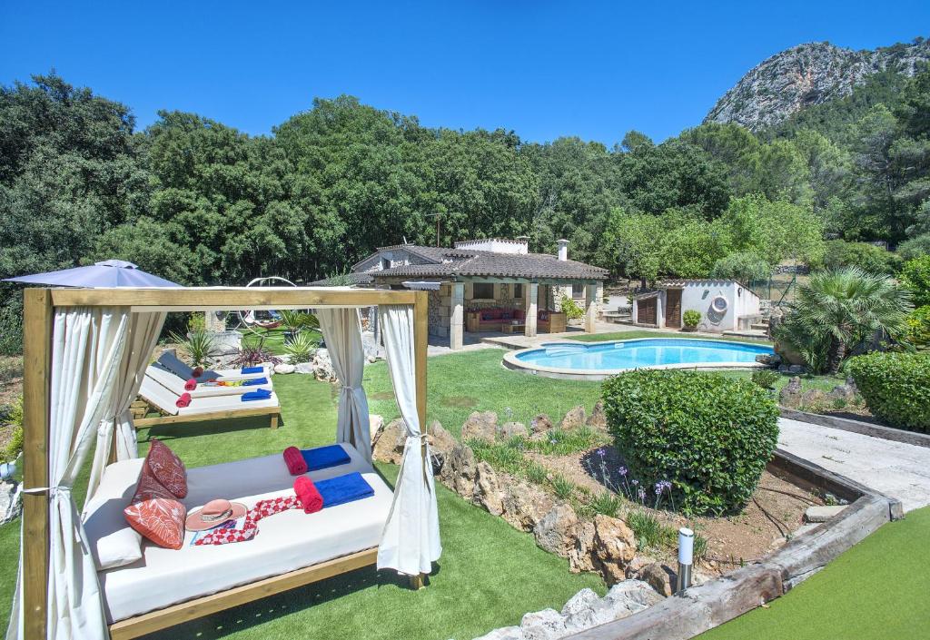a backyard with a swing and a swimming pool at Owl Booking Villa Can Demana - Retreat in the Midst of Nature in Pollença