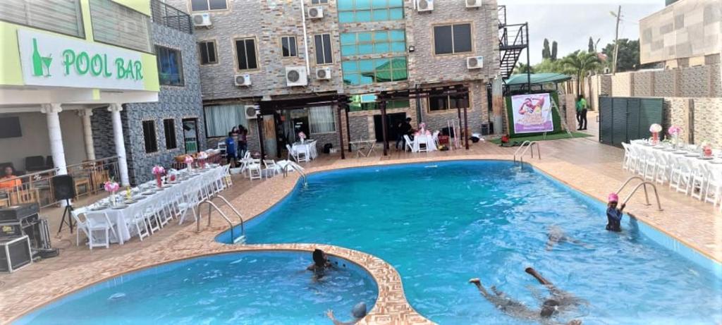 a swimming pool in a building with people in the water at Hotel Green in Spintex