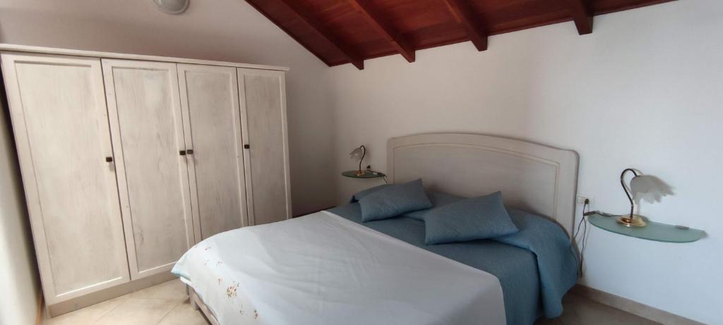 a bedroom with a bed with two blue pillows at Sal Service new studio penthouse in Santa Maria