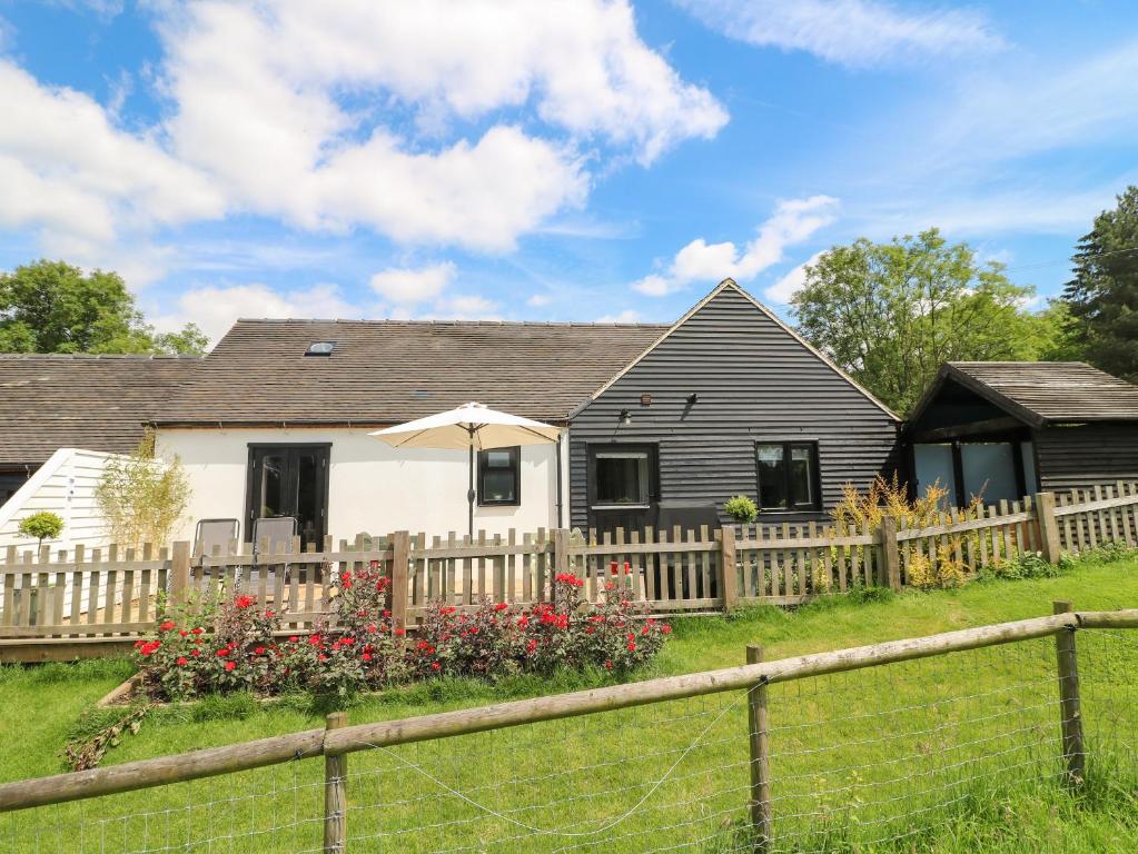 a house with a wooden fence and a yard at The Coach House, Bank Top Farm in Ashbourne