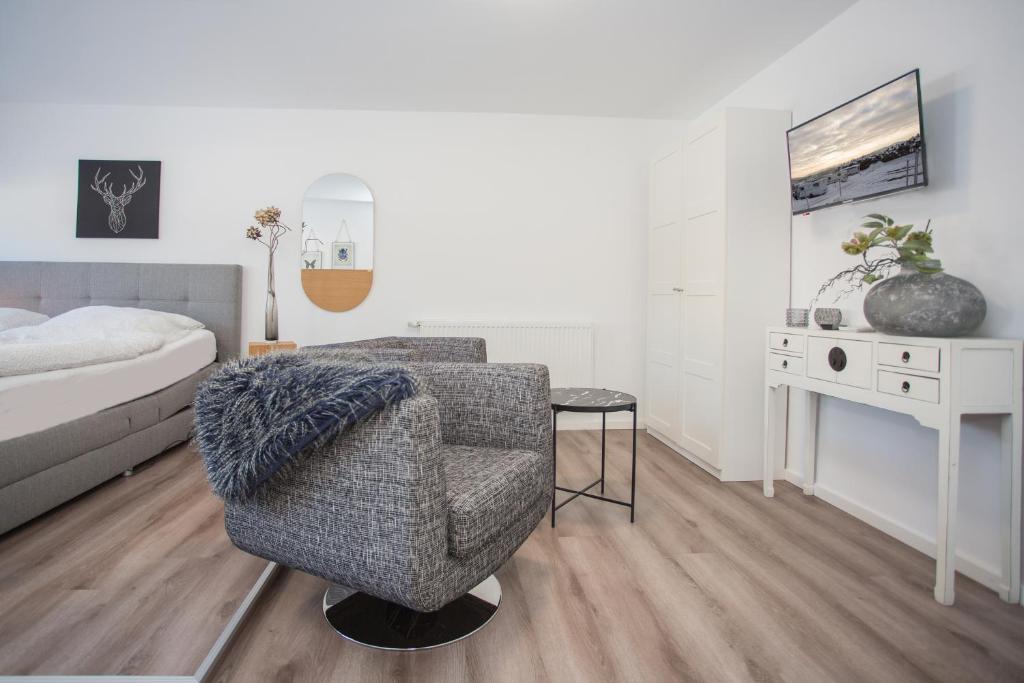 een slaapkamer met een bed, een stoel en een bureau bij NaturLiebe in Winterberg