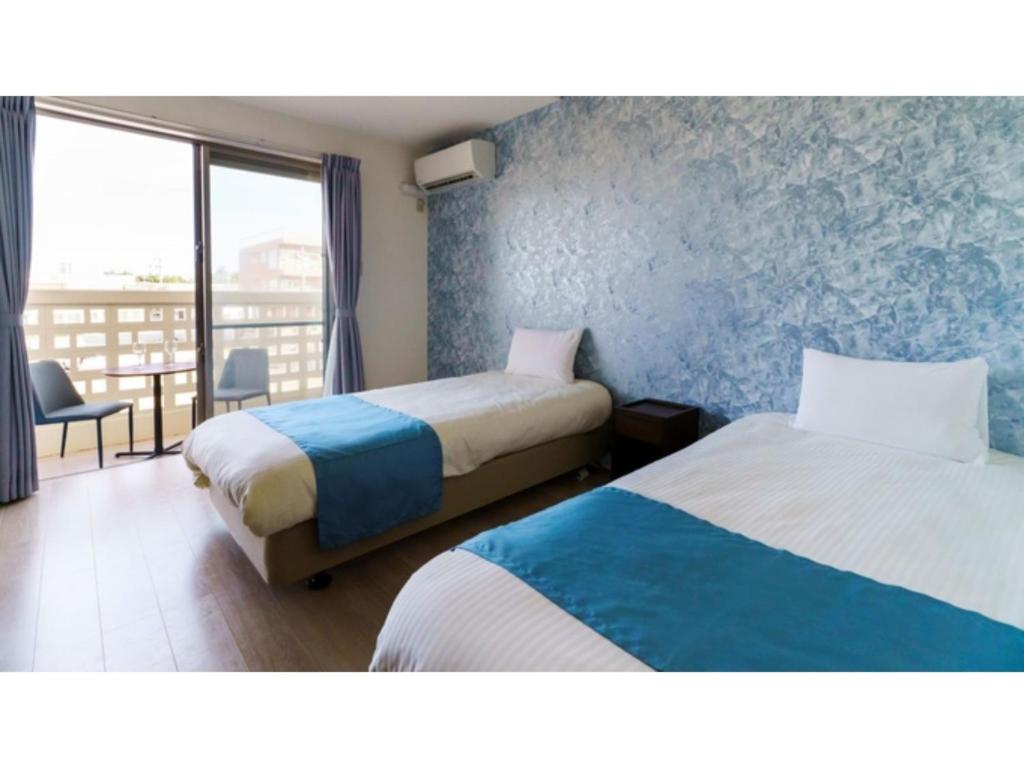 a hotel room with two beds and a balcony at Bears Stay Kumejima Eef Beach - Vacation STAY 85666v in Kumejima