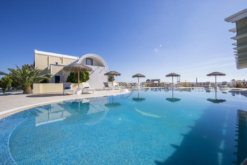 a swimming pool with a large white swimming pool at Bella Santorini in Perivolos