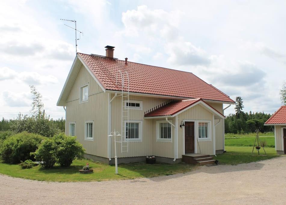 a small white house with a red roof at Albertiina in Kurikka