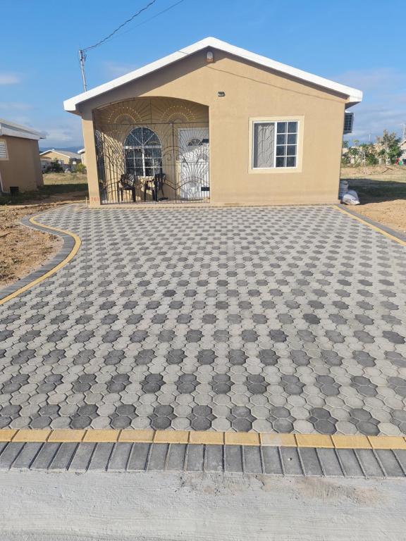 a house with a checkered driveway in front of it at Chad's Island Retreat in Spanish Town