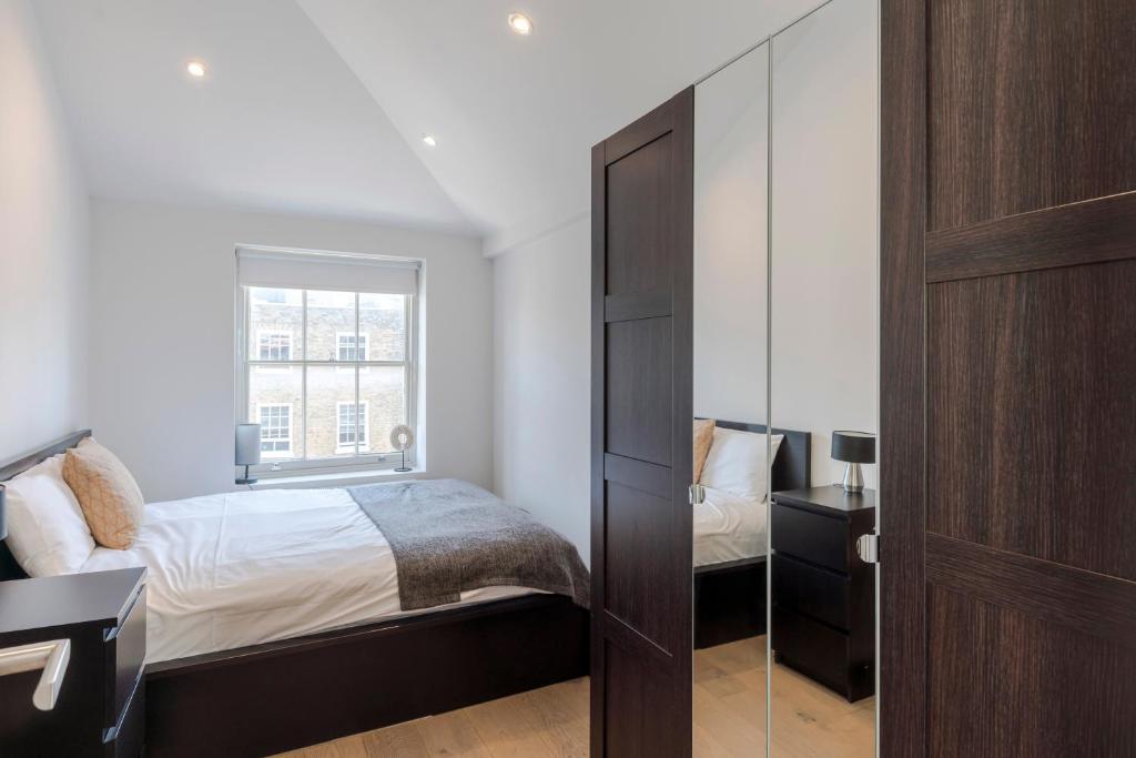 a bedroom with a bed and a window at Marylebone Gloucester Place Apartments in London