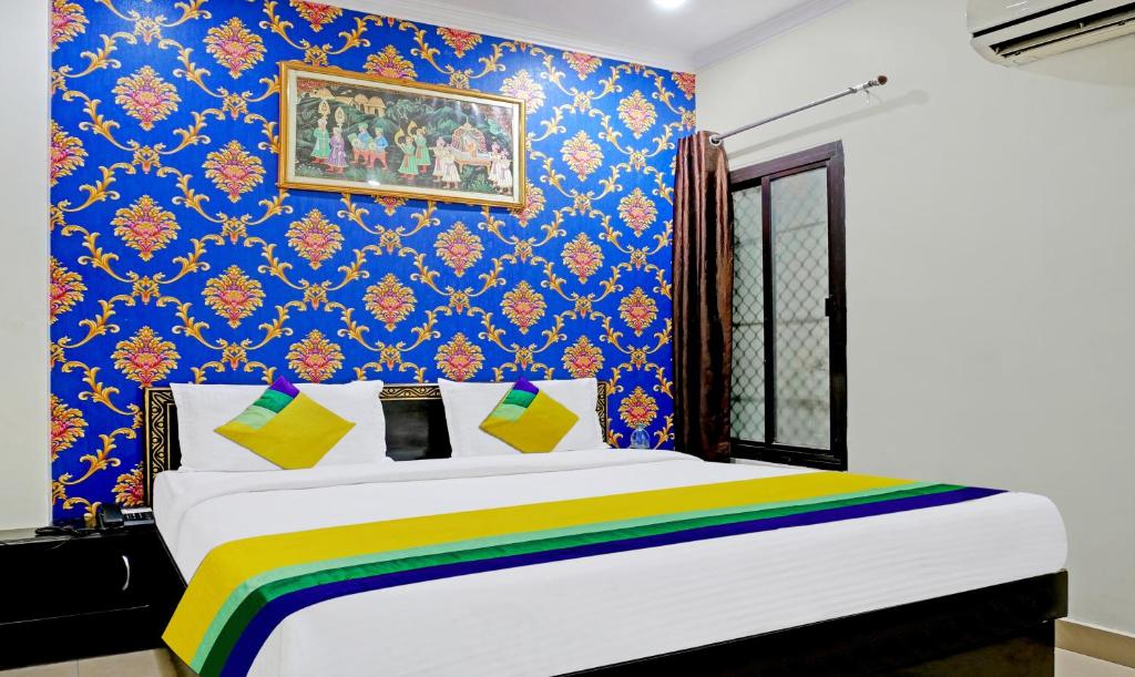 a bedroom with a king sized bed with a colorful wall at Itsy By Treebo - Ashoka Grand in Varanasi