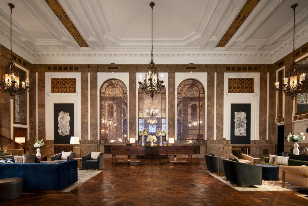 a lobby with a table and chairs and a chandelier at Beacon Grand, A Union Square Hotel in San Francisco