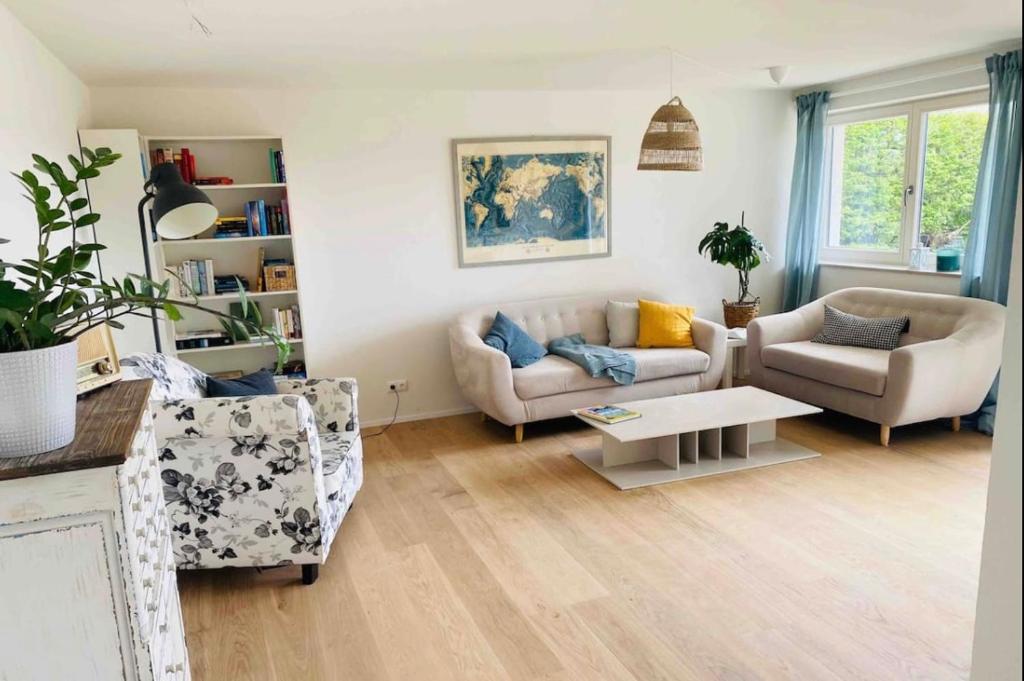 Sala de estar con 2 sofás y mesa en Ferienwohnung mit Traumblick und großem Garten en Lindenberg im Allgäu