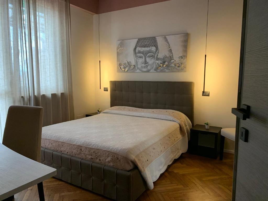 a bedroom with a bed and a picture on the wall at La Favola Apartment Orbassano in Orbassano