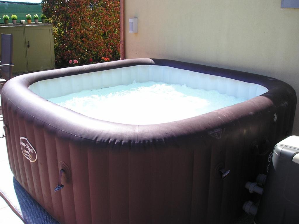 uma grande banheira de hidromassagem sentada num quintal em intero appartamento con giardino e colazione Dario em Parma