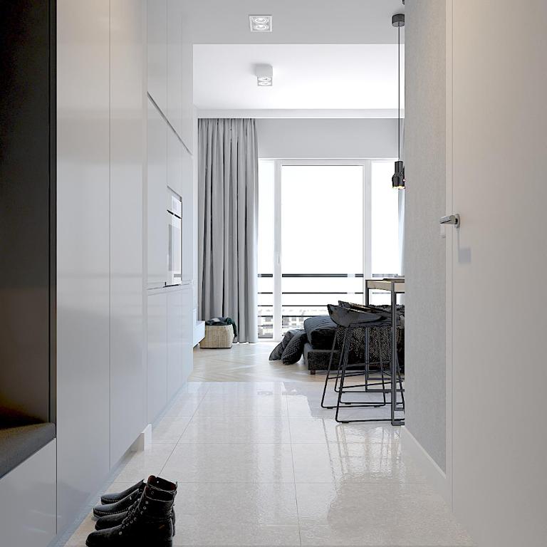 a hallway with white walls and a dining room with a table at Hanza Tower City View 13th floor in Szczecin