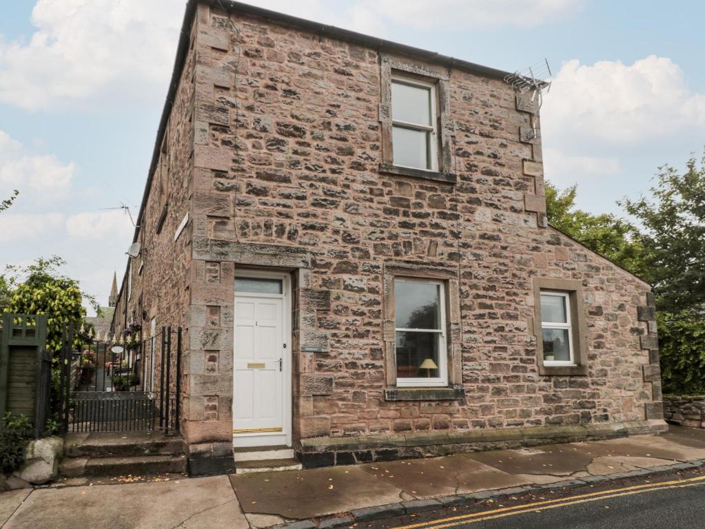 una casa di mattoni con una porta bianca su una strada di Islestone, 1 Temperance Terrace a Berwick-Upon-Tweed
