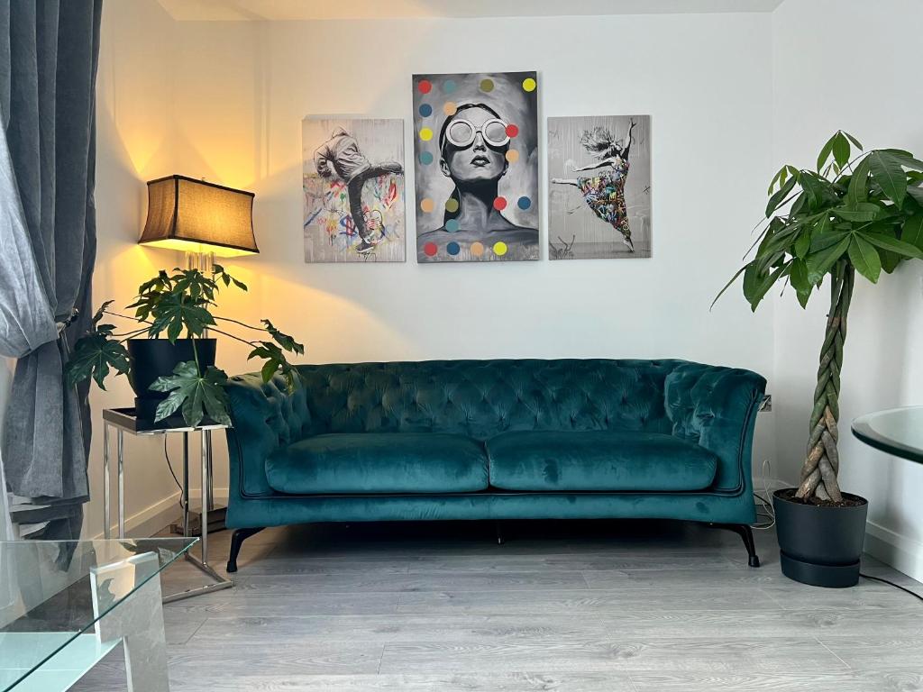 a green couch in a living room with four paintings at Lovely Apartment in Castlebar in Castlebar