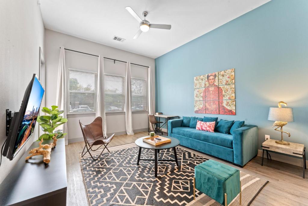 a living room with a blue couch and a tv at Modern & Chic 1BR Luxury Apts Close to Downtown & Airport in Austin