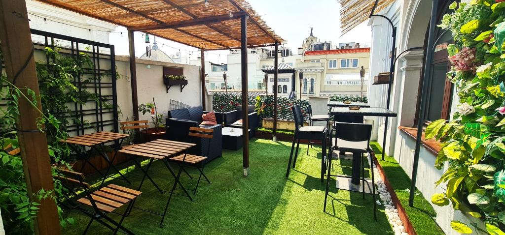 a patio with chairs and tables on a balcony at GREEN Hostel MADRID GRAN VIA in Madrid