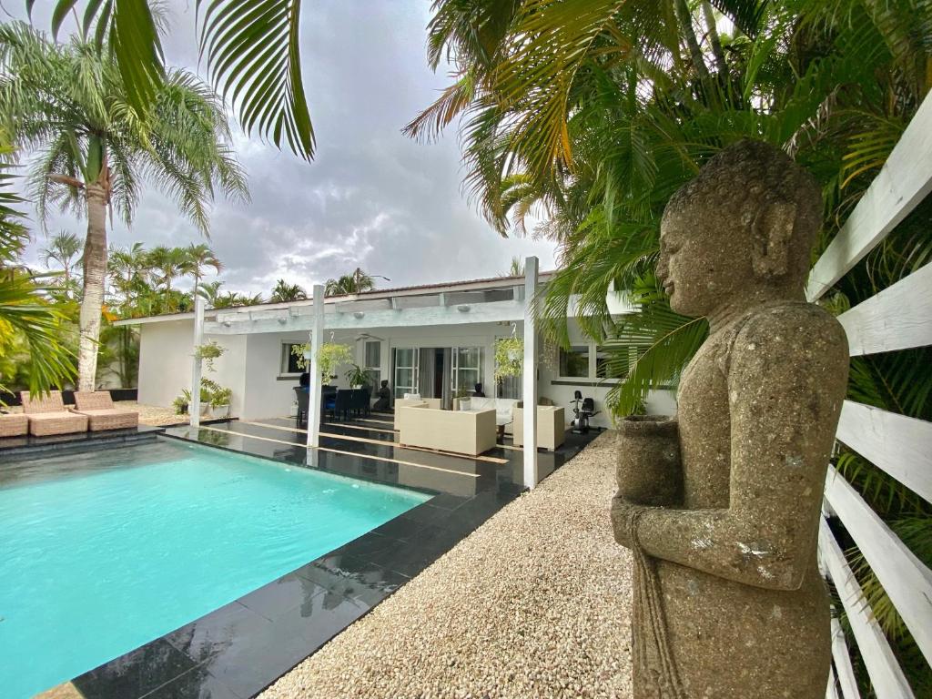una estatua frente a una casa con piscina en EXOTIC VILLA II - Three Bedroom Villa in Juan Dolio Beach, en Juan Dolio