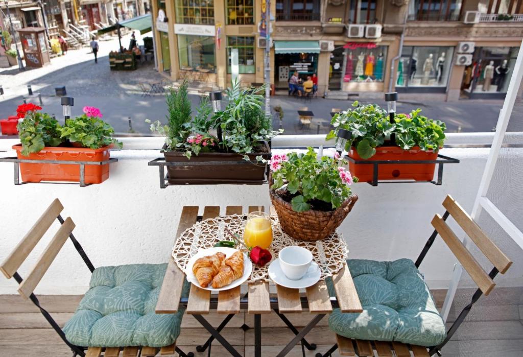 a table with a plate of croissants and a cup of orange juice at Traditional Romanian Apartments Old Town City in Bucharest