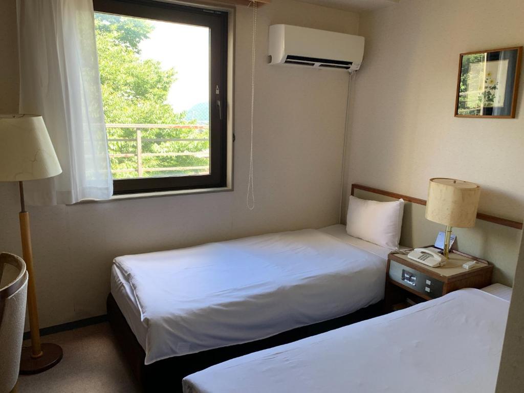 a hotel room with two beds and a window at Hotel Fuyokaku - Vacation STAY 13411v in Fujiyoshida