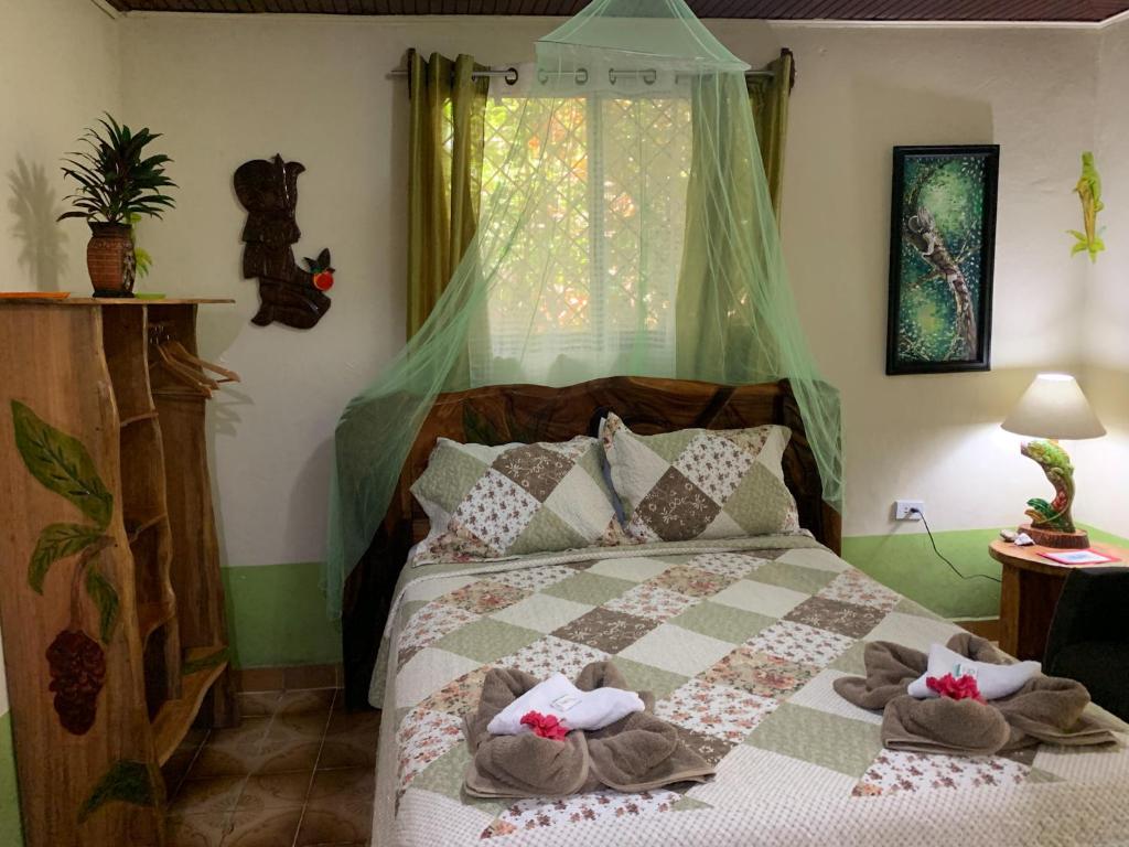 1 dormitorio con 1 cama con toallas en Cabinas Tito, en Cahuita