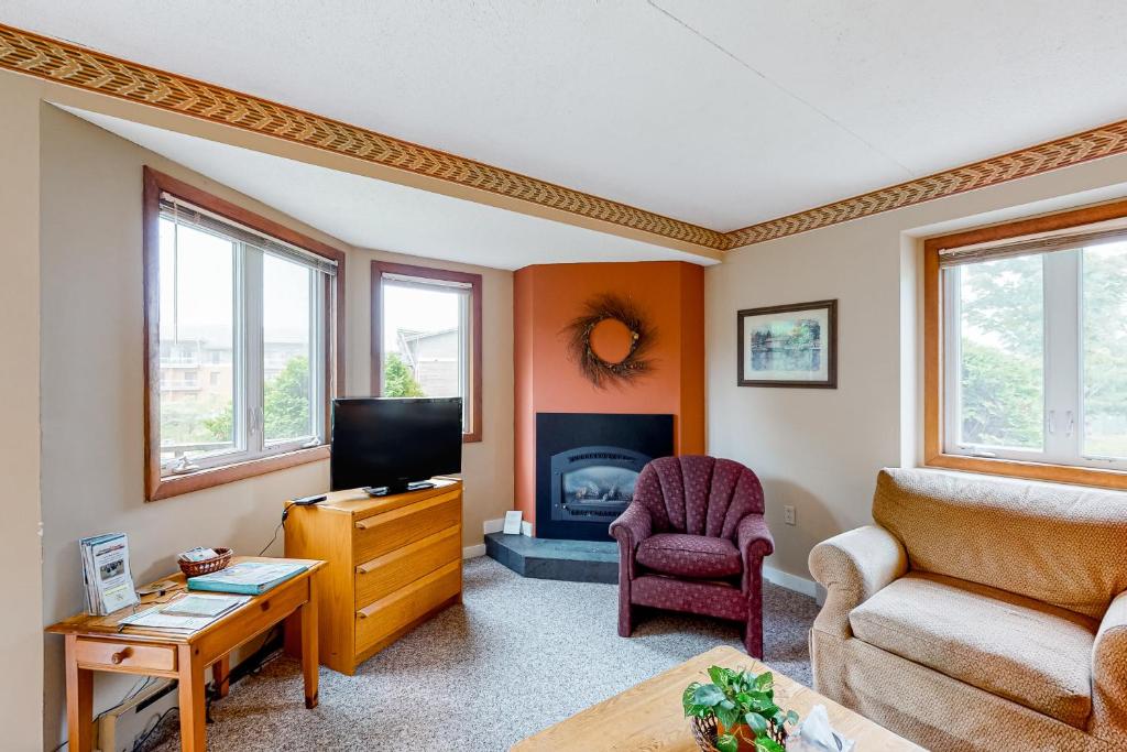 a living room with a couch chair and a television at Slopeside 705 in Jay