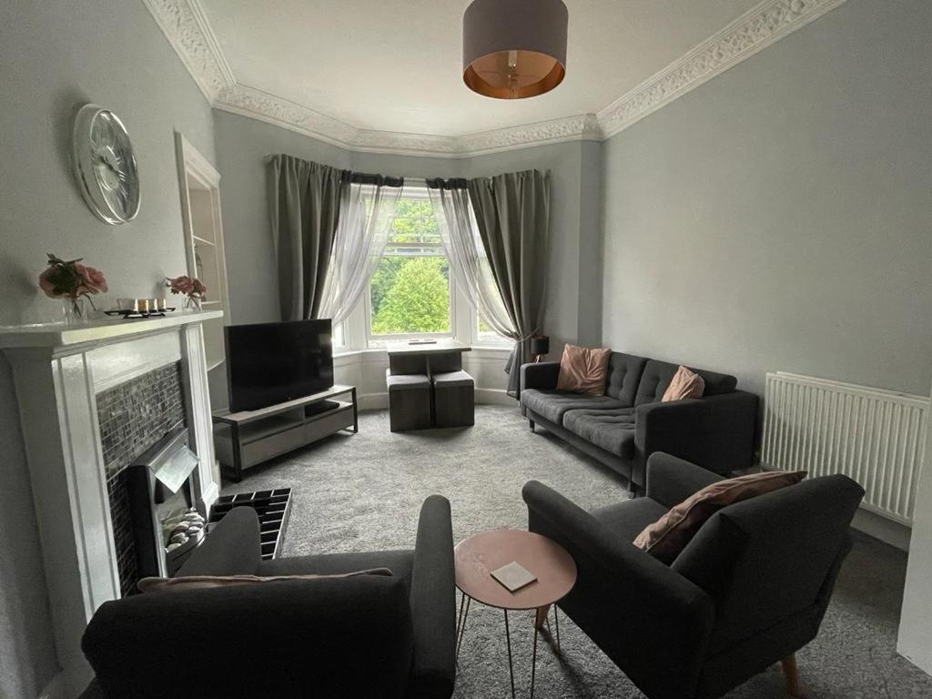 sala de estar con sofá y chimenea en Our Wee Getaway, en Rothesay