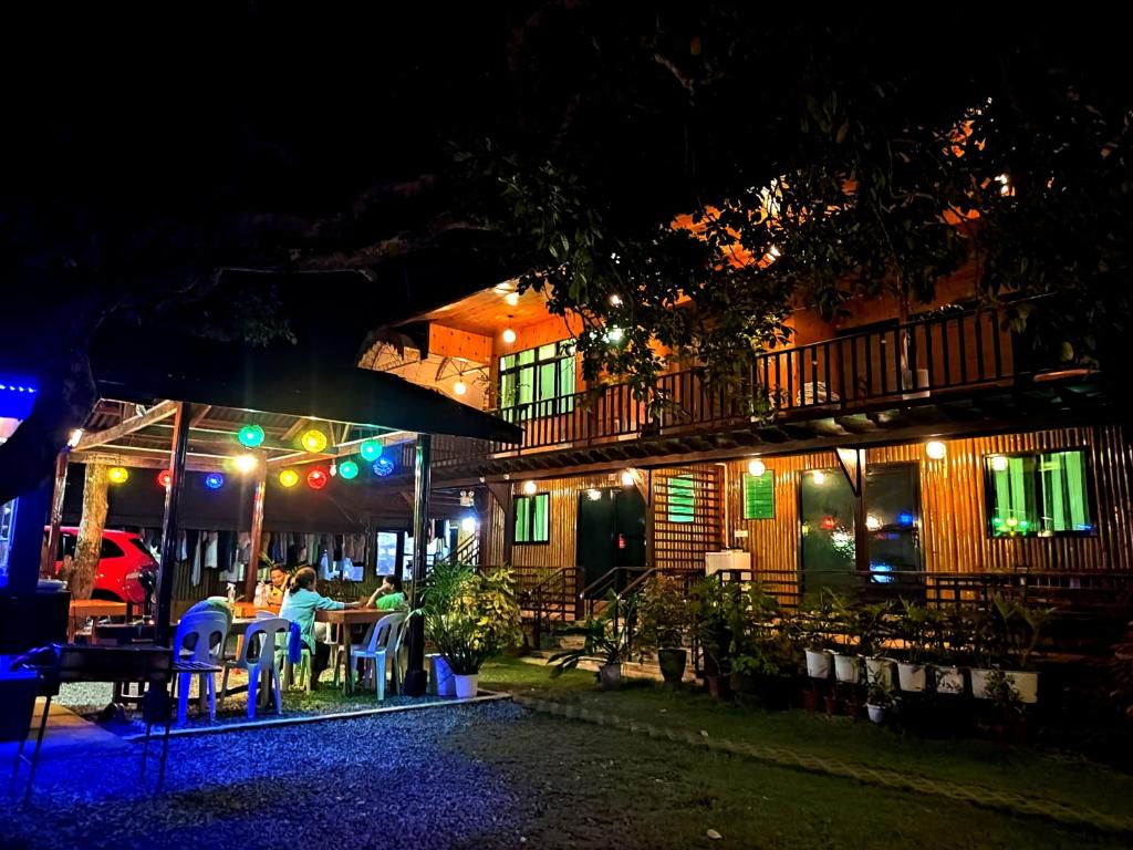 Eine Gruppe von Menschen, die nachts am Tisch sitzen in der Unterkunft Pitaya Native Guest House in Panglao