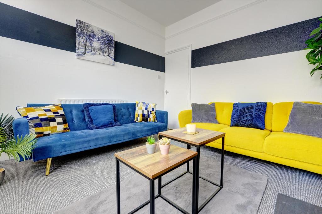a living room with two blue and yellow couches at Cheerful 2 Bedroom Home, Sleeps 5 Guest Comfy, 1x Double Bed, 3x Single Beds, Free Parking, Free WiFi, Suitable For Business, Leisure Guest,Coventry, Midlands in Coventry