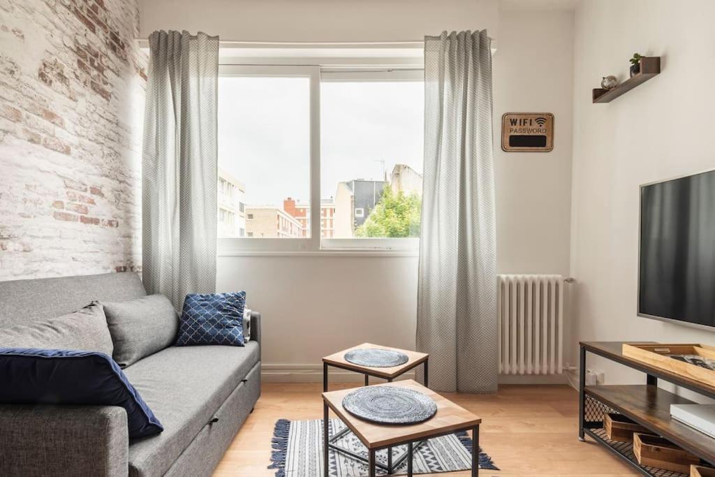 a living room with a couch and a television at Centre Ville LH - Parking - B'PAM in Le Havre