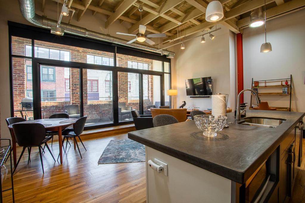 a kitchen and living room with a table and chairs at The Press Loft in Asheville