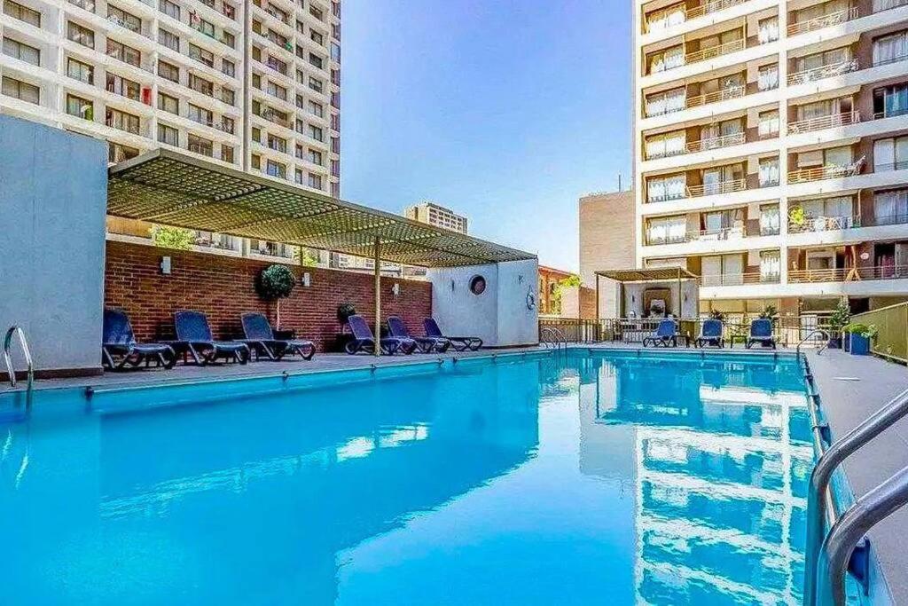 聖地亞哥的住宿－Grato y céntrico depto entre Providencia y Ñuñoa，酒店内有一个蓝色的游泳池