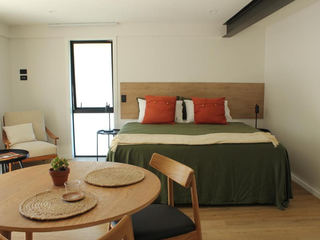 a bedroom with a large bed and a table at māra in Mapua