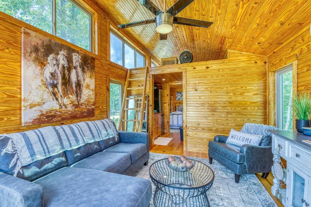 ein Wohnzimmer mit Couch und Tisch in der Unterkunft The Gemini-a dreamy, waterfront tiny cabin in Rogersville