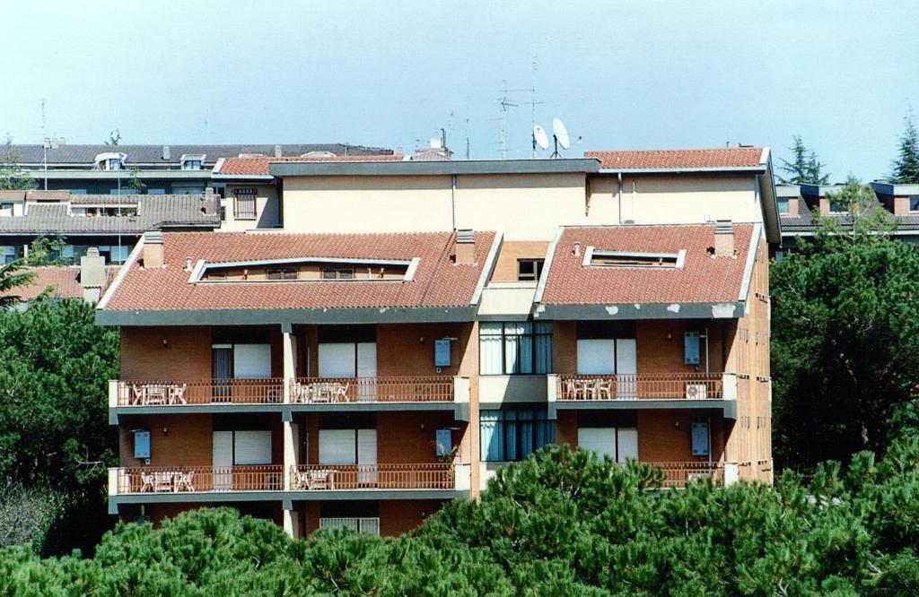 un immeuble d'appartements avec un toit rouge et des arbres dans l'établissement Eur Nir Residence, à Rome