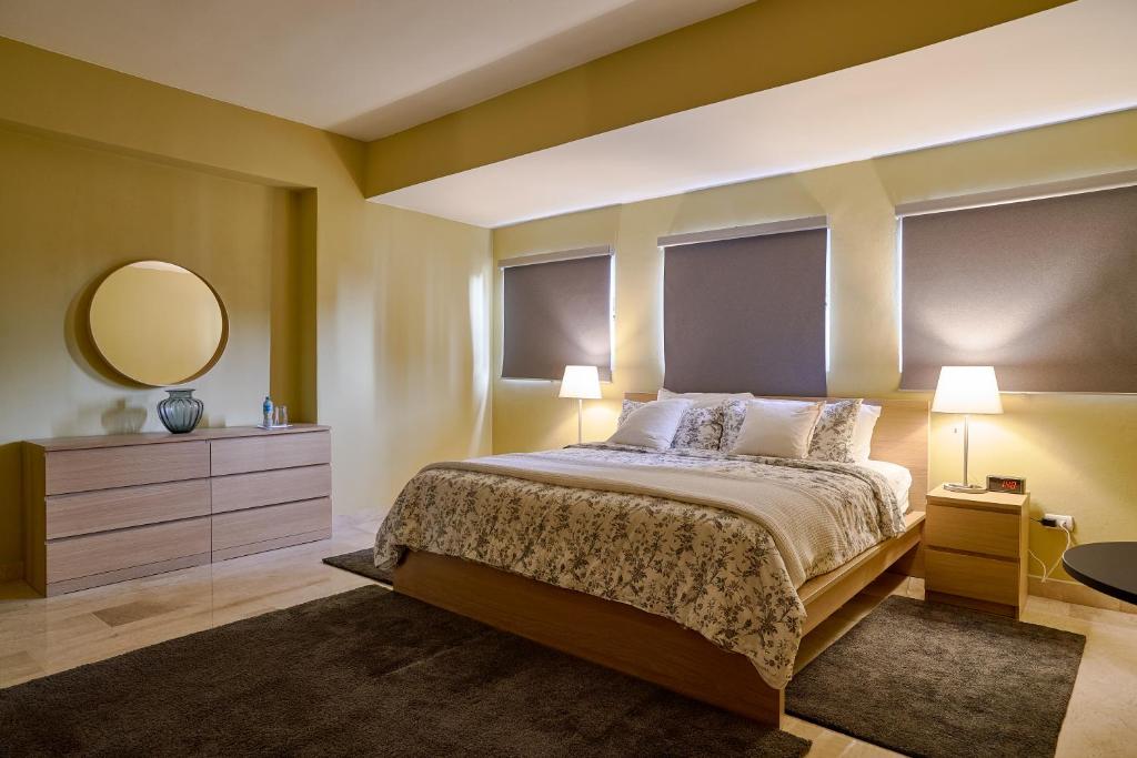 a bedroom with a large bed and a mirror at Harmony Apartament in the Heart of Piantini in Santo Domingo