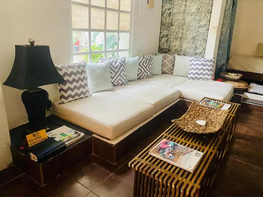sala de estar con sofá blanco y mesa en ACASADIALEXPLAYADELCARMEN Home with mini pool, en Playa del Carmen