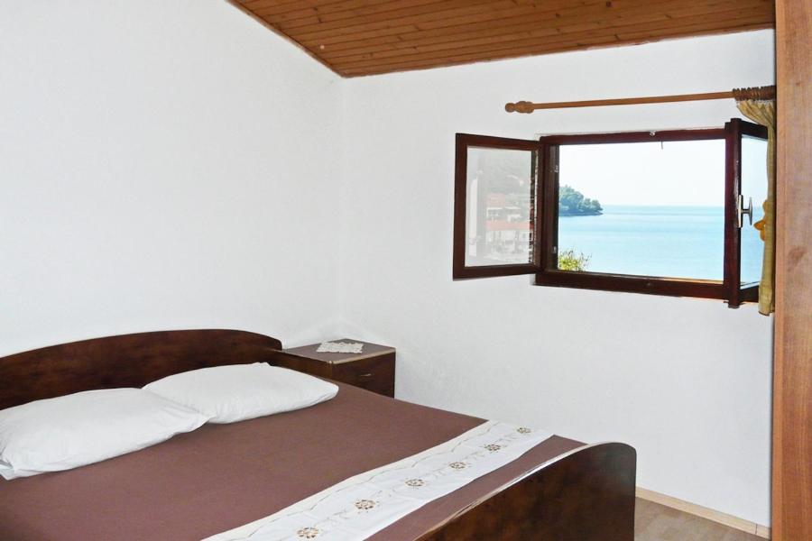 a bedroom with a bed and a window with the ocean at Apartments by the sea Brna, Korcula - 5902 in Smokvica