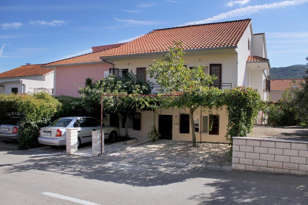 uma casa com um carro estacionado em frente em Apartments with a parking space Stari Grad, Hvar - 5724 em Stari Grad