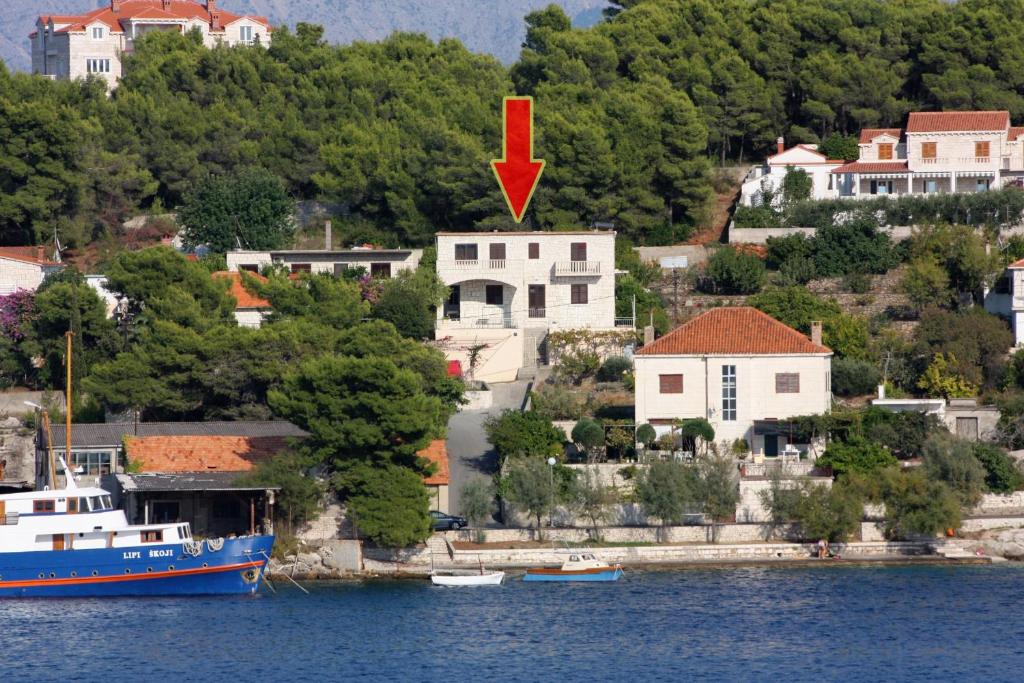 a boat is docked in front of a house at Family friendly seaside apartments Sumartin, Brac - 5771 in Sumartin