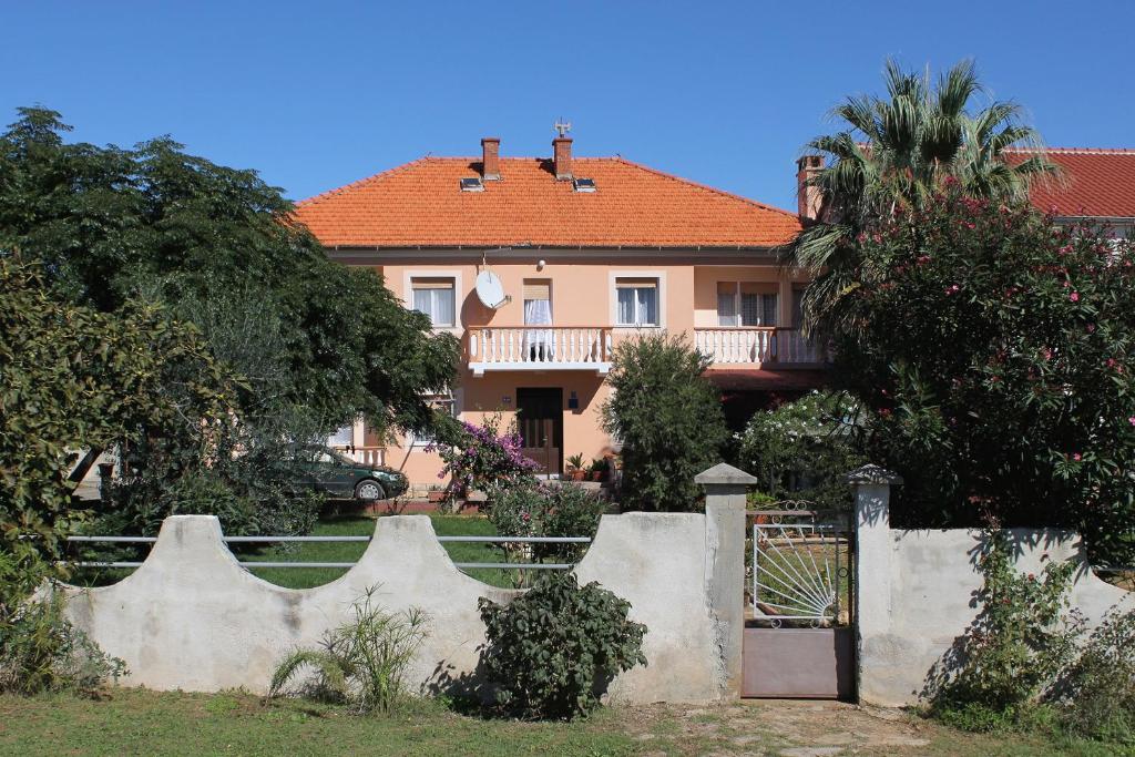 uma casa com uma cerca em frente em Apartments for families with children Privlaka, Zadar - 5747 em Privlaka