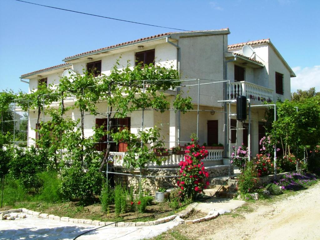 dom z kwiatami przed nim w obiekcie Apartments by the sea Vrsi - Mulo, Zadar - 5791 w mieście Vrsi