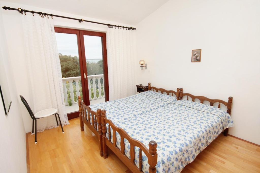 sypialnia z łóżkiem i oknem w obiekcie Apartments by the sea Vrsi - Mulo, Zadar - 5791 w mieście Vrsi