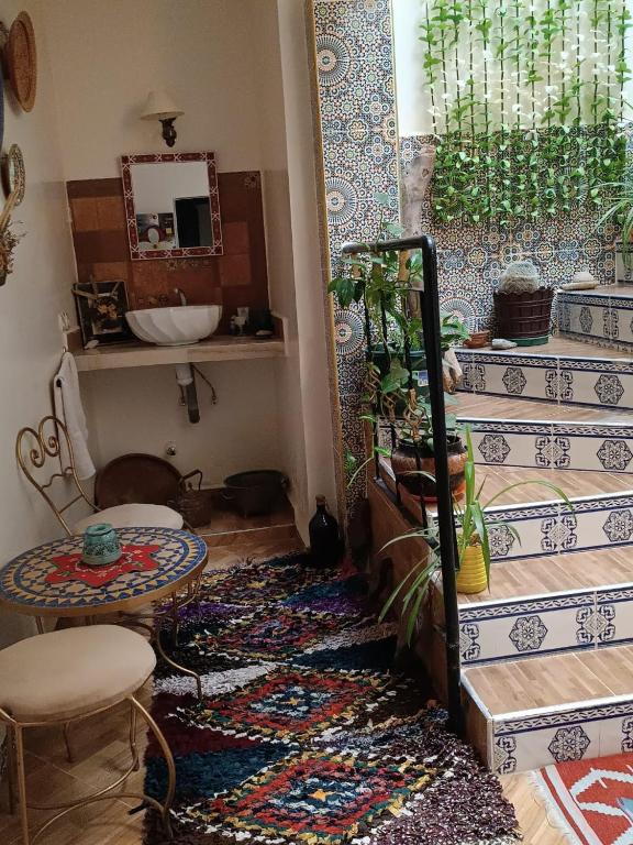 een kamer met een trap, een tafel en een tapijt bij Chez Fatima in Agadir