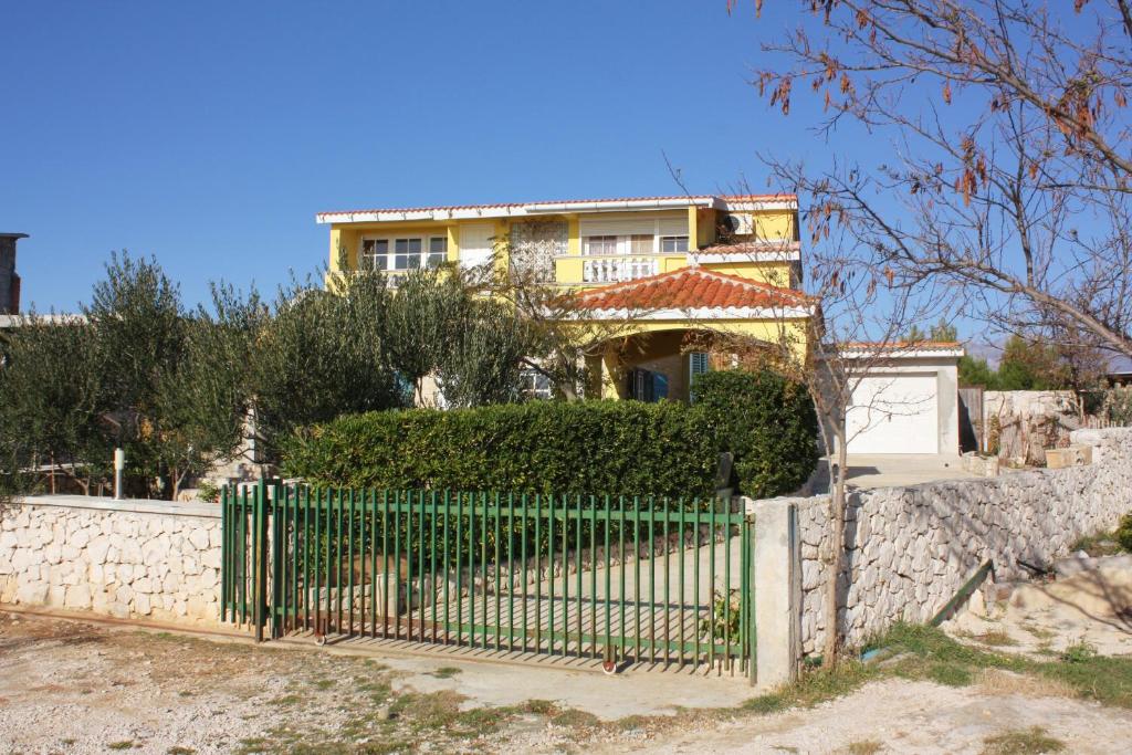a yellow house with a fence in front of it at Apartments with a parking space Rtina - Stosici, Zadar - 5881 in Ražanac