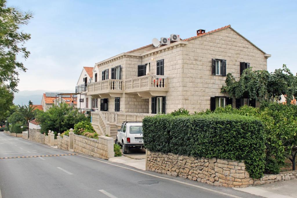 a house on the side of a street at Apartments with a parking space Supetar, Brac - 5676 in Supetar