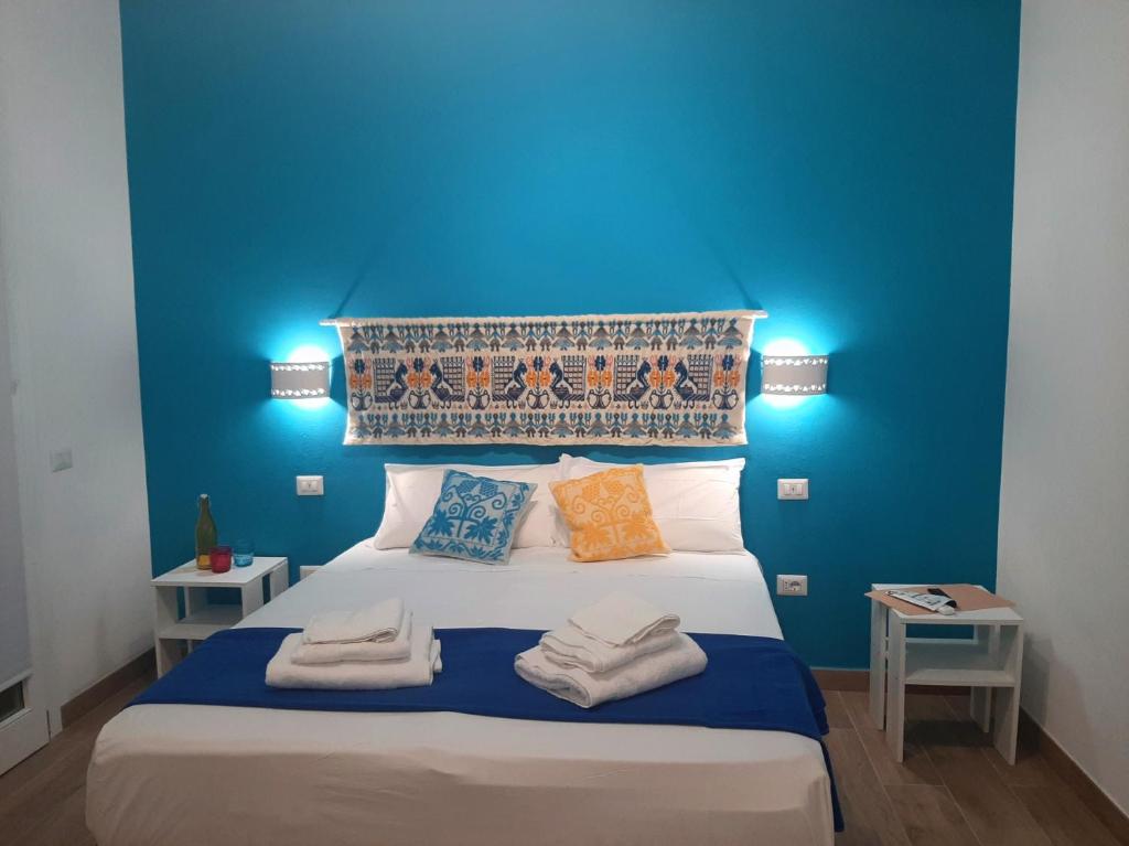 een blauwe slaapkamer met een bed met handdoeken erop bij Camera Olbia Centro, vacanze Olbia e dintorni in Olbia