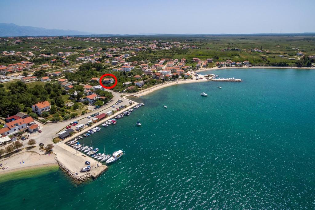 eine Luftansicht auf einen Strand mit einem roten Kreis in der Unterkunft Apartments and rooms by the sea Vrsi - Mulo, Zadar - 5848 in Vrsi