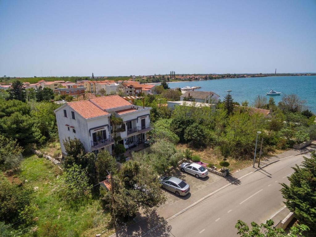 z góry widok na dom z samochodami zaparkowanymi na ulicy w obiekcie Apartments and rooms by the sea Vrsi - Mulo, Zadar - 5848 w mieście Vrsi