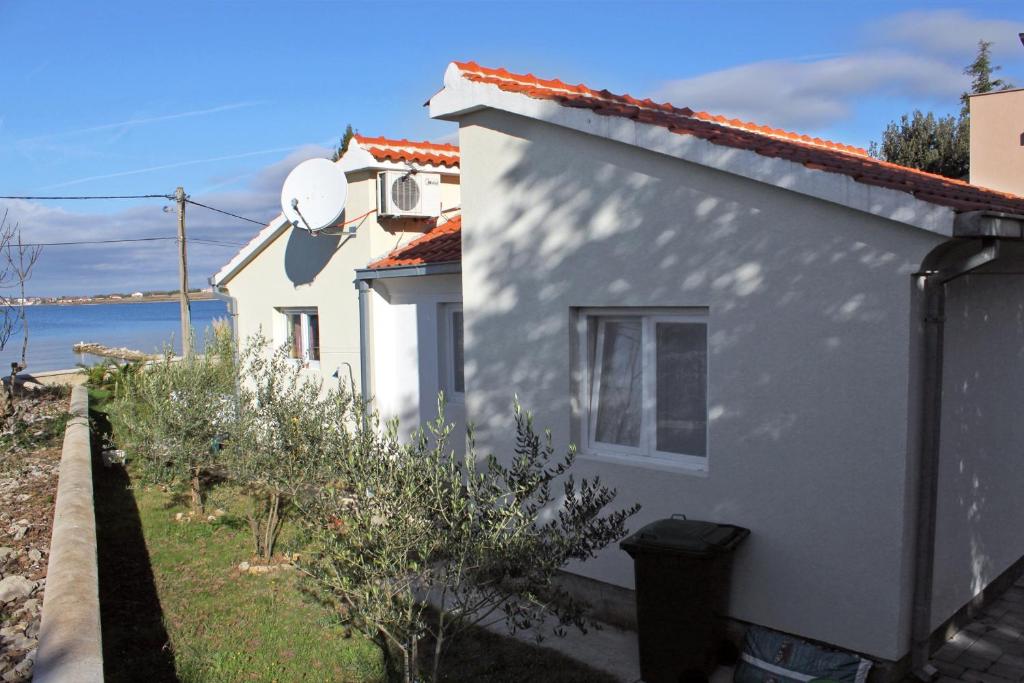 Una casa blanca con una ventana en el costado. en Seaside holiday house Zaton, Zadar - 5910, en Zaton